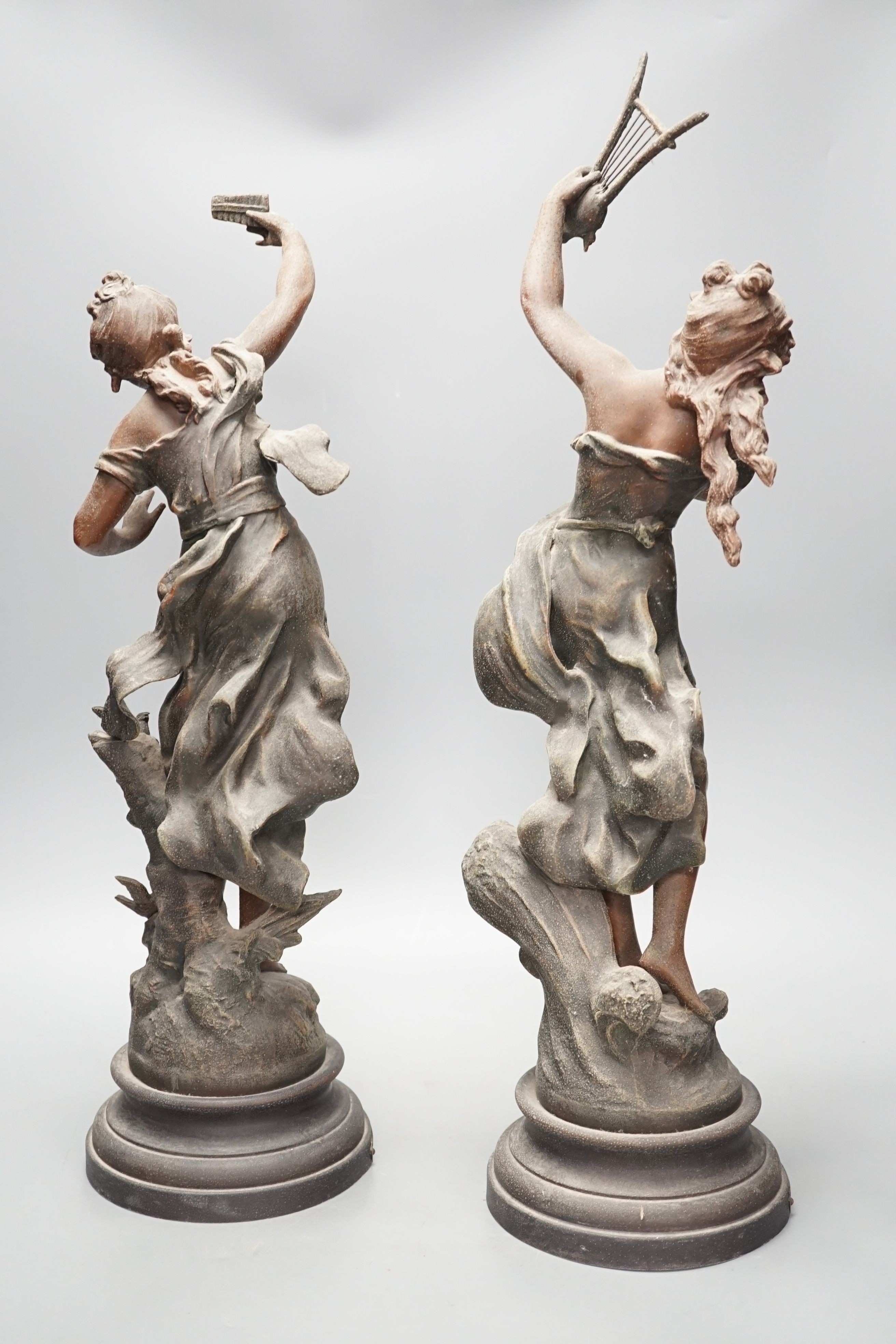 A pair of patinated spelter figures of musical maidens, tallest 58 cms high.